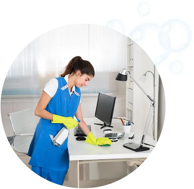 A woman in blue cleaning the floor of an office.