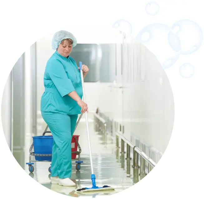 A woman in blue scrubs and white gloves mopping the floor.